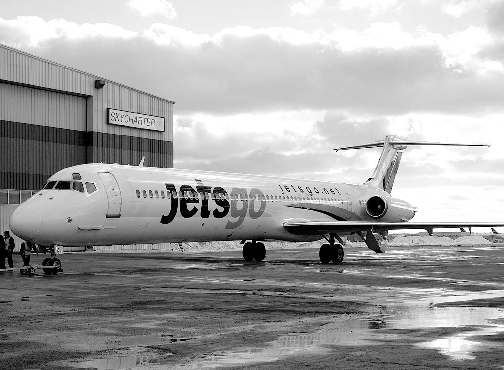 Photo: Appareil MD-83 de Jetsgo prêt à être remorqué dans un hangar à l’Aéroport international Pearson de Toronto, février 2015. (Photo : Duke. Utilisée en vertu de la licence Creative Commons.)